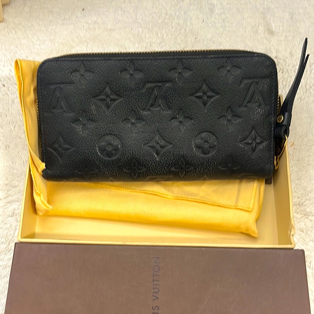LV navy leather embossed 8 in x 4 in wallet with zip closure.